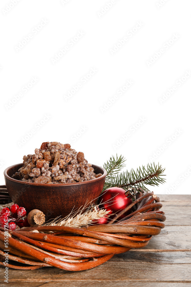 Bowl of Kutya and Christmas wreath on table against white background