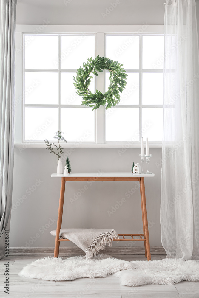 Interior of living room with Christmas wreath on window and table