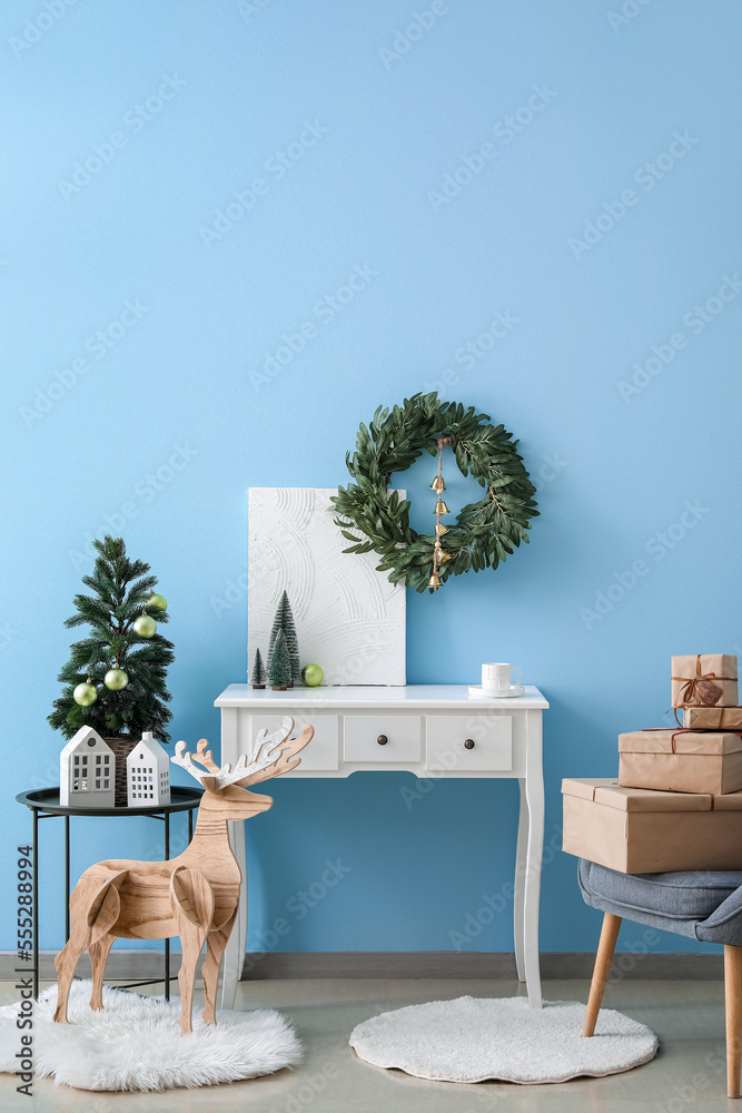 Interior of living room with Christmas wreath, fir trees and table