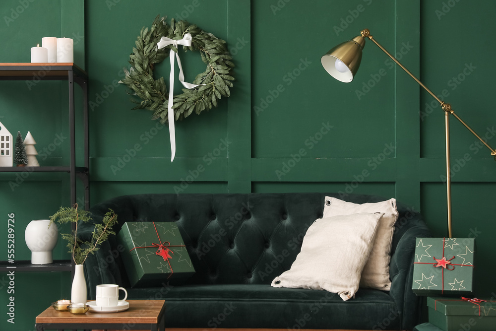 Interior of living room with Christmas wreath, sofa and shelving unit