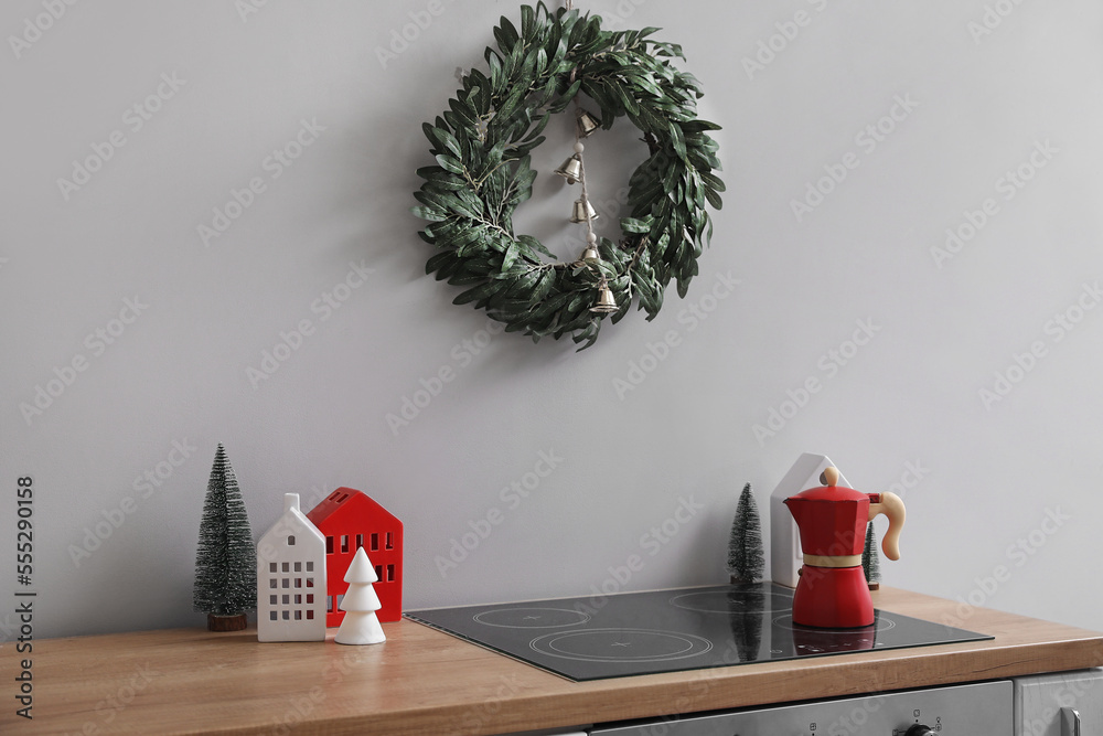 Christmas wreath hanging on grey wall in kitchen