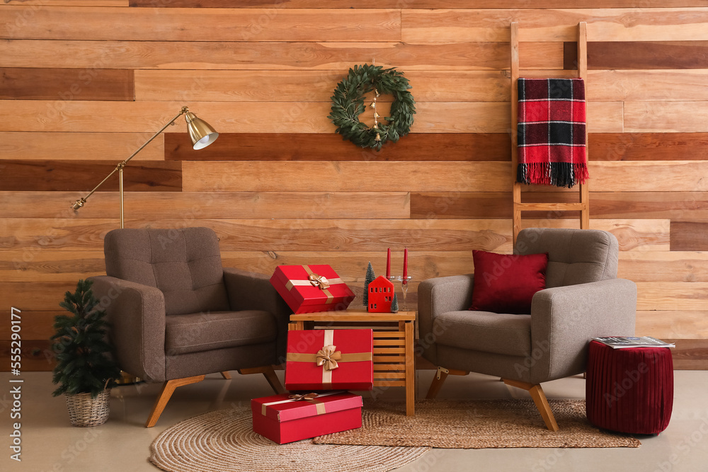 Interior of living room with Christmas wreath, armchairs and presents