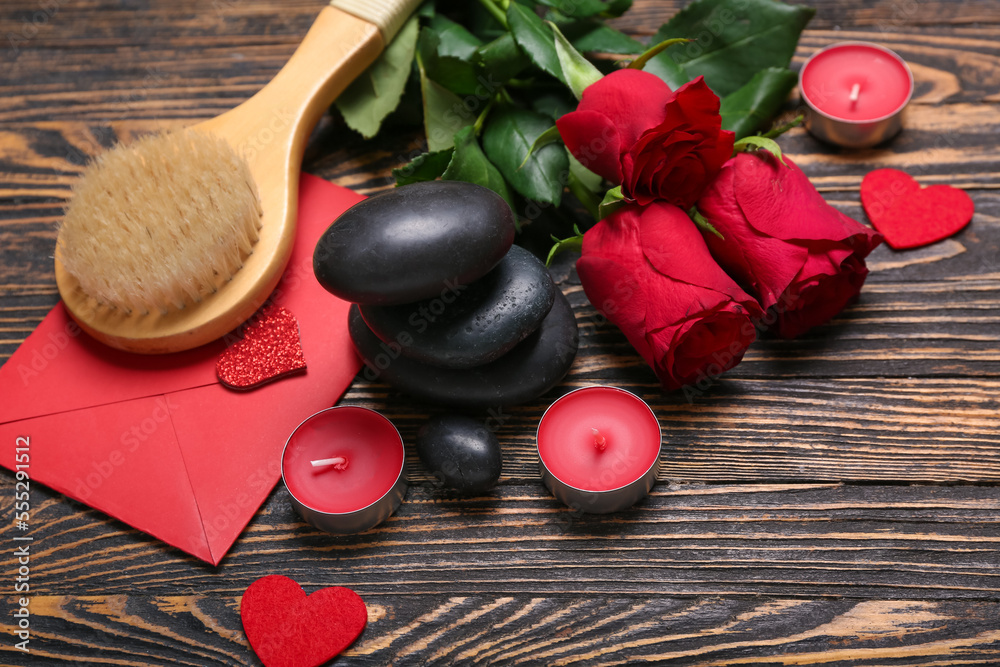 Beautiful spa composition for Valentines Day with rose flowers, stones, brush, envelope and candles