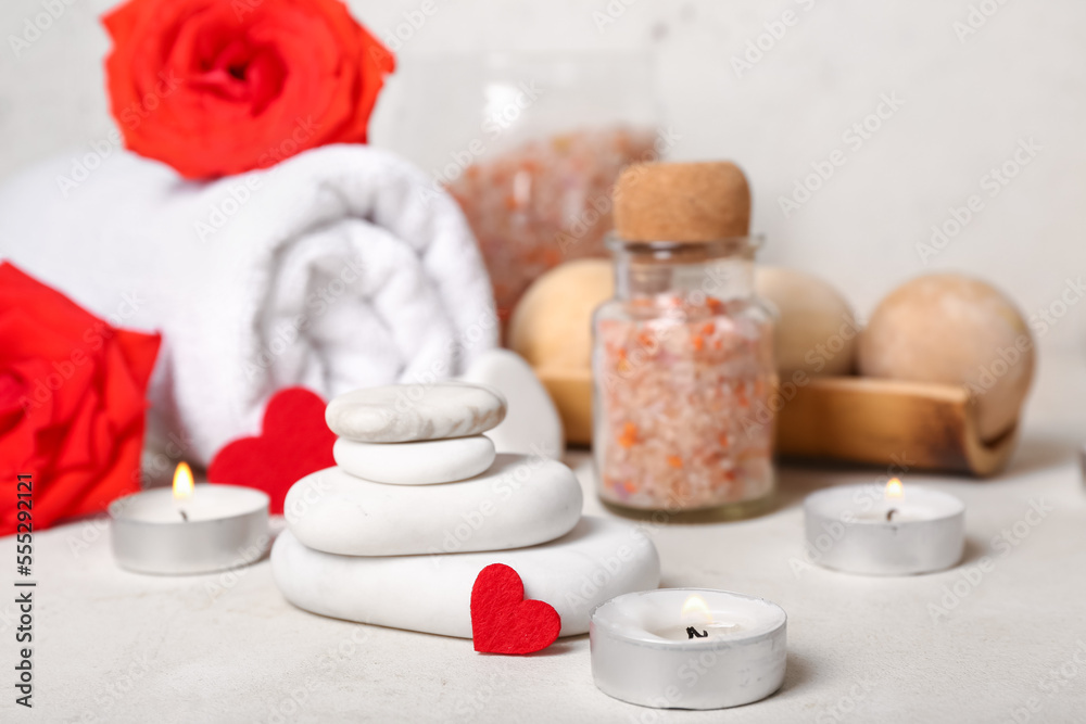 Beautiful spa composition for Valentines Day with candles and stones on light background