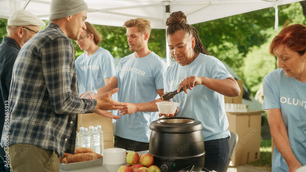 Positive Group of Young Adult Volunteers Serving Free Food for Poor People in Need. Charity Workers 