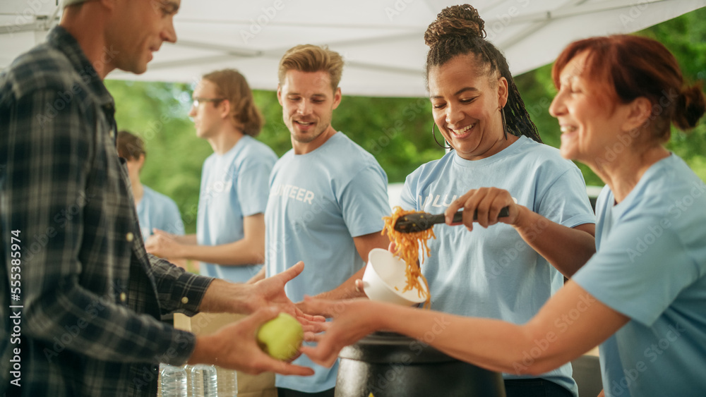 The Concept of Giving: Homeless People Reach Out To Free Volunteer Meals from Multiethnic Team of Vo