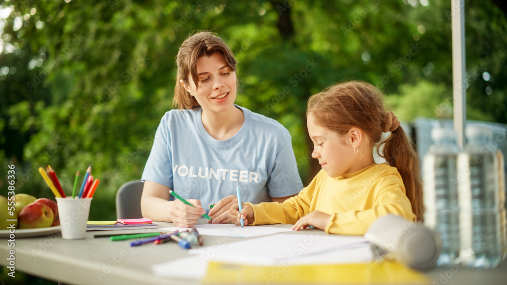 Volunteer from a Local Humanitarian Aid Organization Teaching a Talented Little Girl to Draw with Co