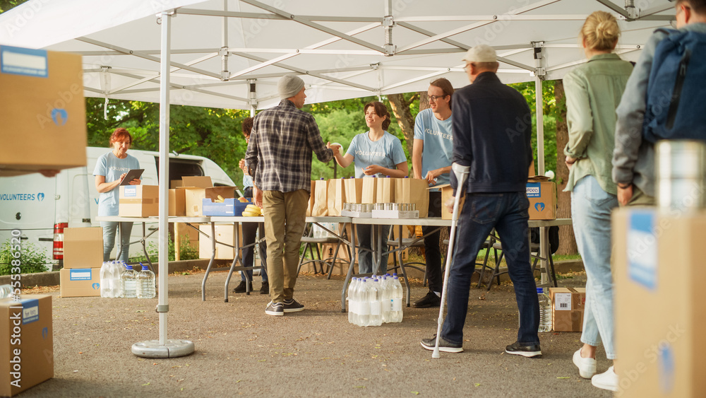 Establishing Shot of a Group of Volunteers Handing Out Food Rations for Poor People in Need. Charity