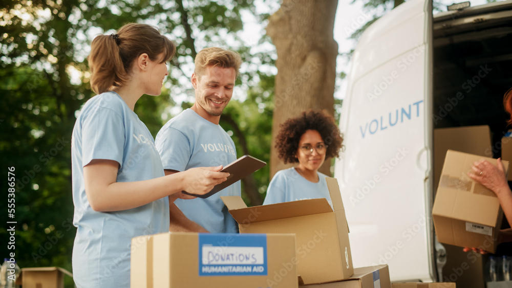 Positive Group of Hardworking Volunteers Preparing Donated Free Food Rations, Loading Packages in a 