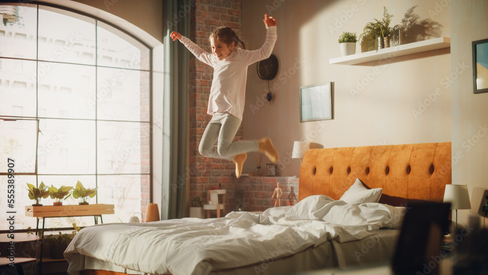 Adorable Little Girl Having Fun at Home, Running Around and Jumping on a Bed in Stylish Bedroom in L