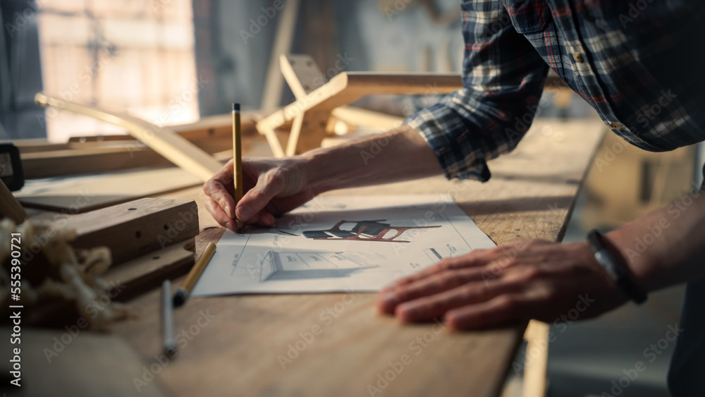 Portrait of a Young Carpenter Looking at a Blueprint and Starting to Assemble a Wooden Chair. Profes