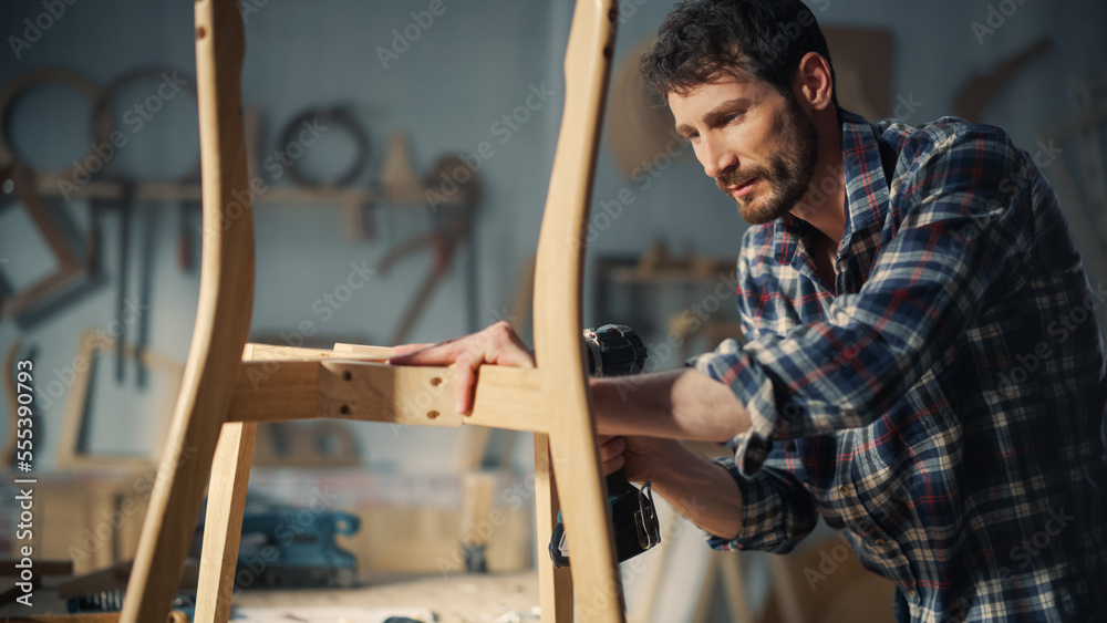 Close Up Portrait of a Furniture Designer Reading Blueprint and Assembling Legs of a Wooden Chair wi