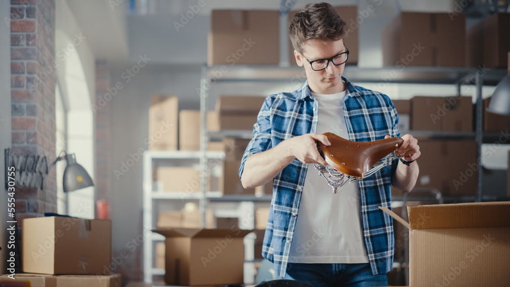 Small Business Owner Works on Laptop Computer while Standing at His Desk in Warehouse. Employee Pack