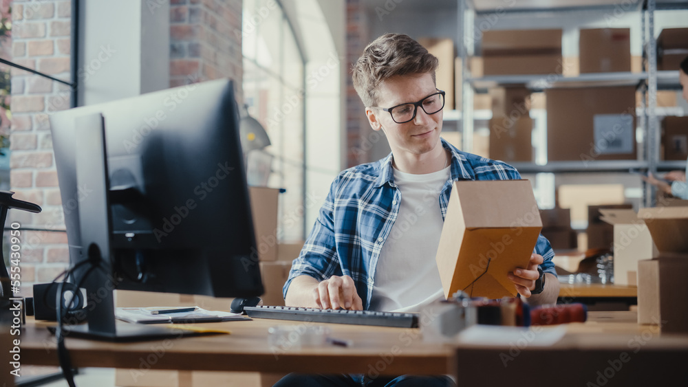 Small Business Owner Checks Stock and Inventory on Desktop Computer in the Retail Warehouse full of 