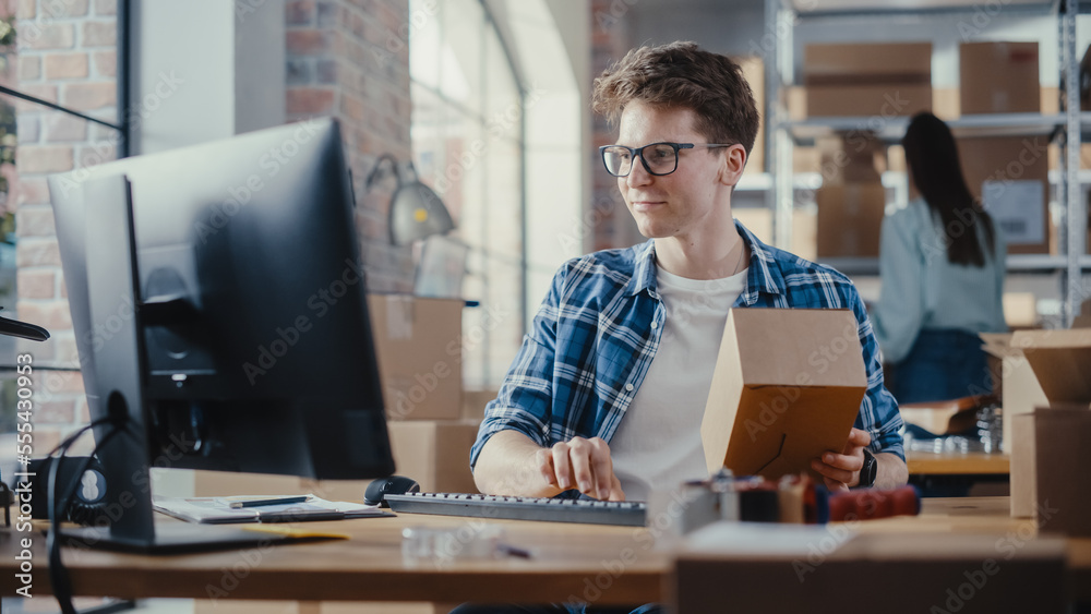 Small Business Owner Checks Stock and Inventory on Desktop Computer in the Retail Warehouse full of 