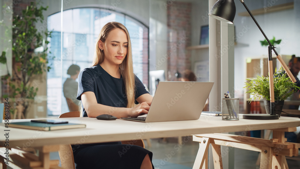 Beautiful Female in a Black Casual Dress Sitting at a Desk in Creative Office, Working on Tasks on L