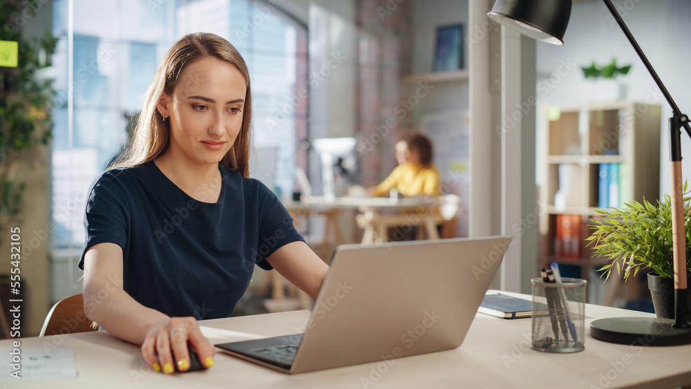 Creative Female Working on Laptop Computer in a Company Office. Happy Young Project Manager Browsing