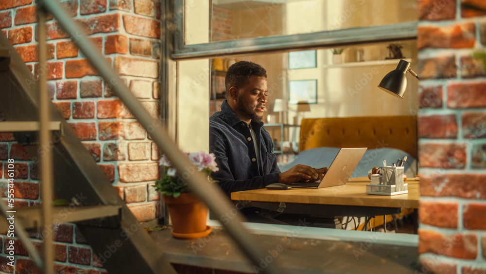 Tired African Male Using Laptop at Home. Doing Remote Work During the Day. Frustrated Man Sitting at