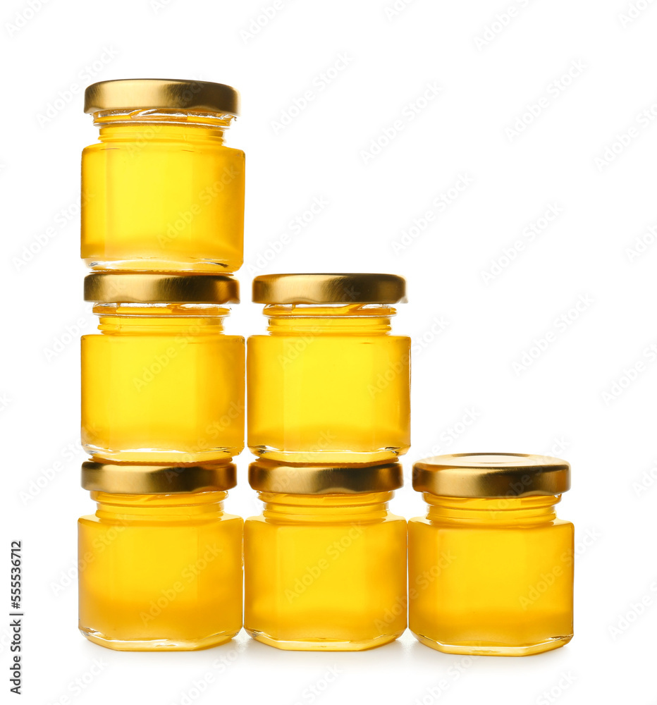 Delicious honey in jars on white background