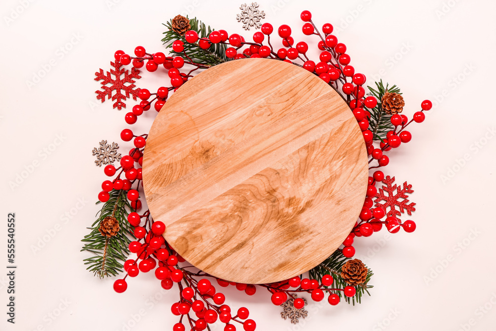 Composition with wooden cutting board and Christmas decor on light background