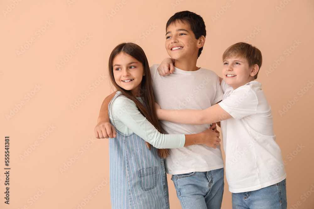 Little friends hugging near beige wall