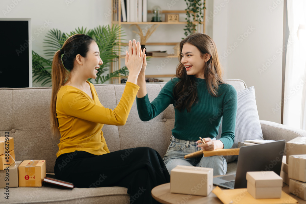  Asian women and woman at office of their business online shopping.In home office