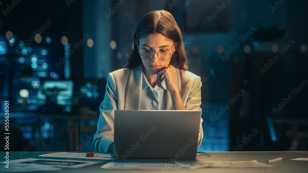 Beautiful Female Working on Laptop Computer in a Company Office at Night. Young Secretary Analyzing 