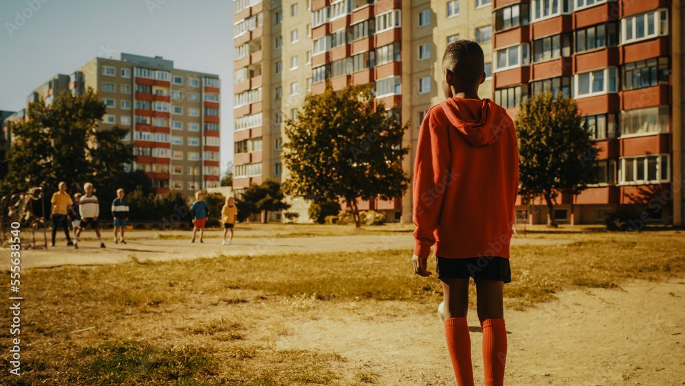 Young Black Boy Playing Soccer with Friends. Multiethnic Kids Enjoying a Game of Football in the Nei