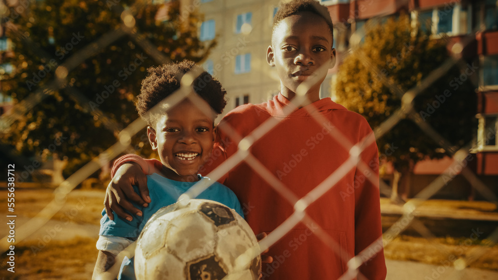 Portrait of Two Young Handsome Black Boys Embracing Each Other while Looking at Camera and Smiling. 