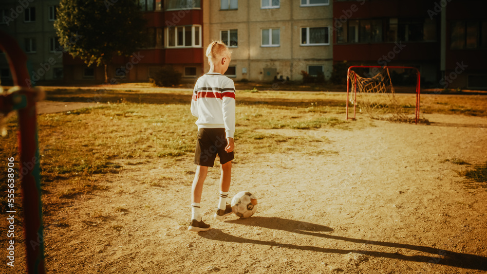 Sporty Caucasian Kid Playing with Ball in the Neighborhood. Young Boy Practicing Soccer Drills, Shoo