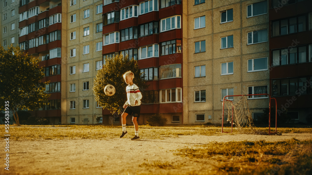 Young Caucasian Kid Playing with Ball in the Neighborhood. Young Boy Practicing Soccer Drills, Doing