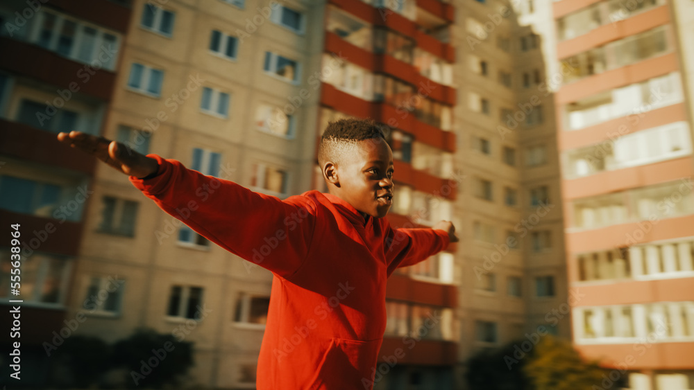 Close Up Portrait of Black Kid Playing with Ball in the Neighborhood. Young African Boy Practicing S