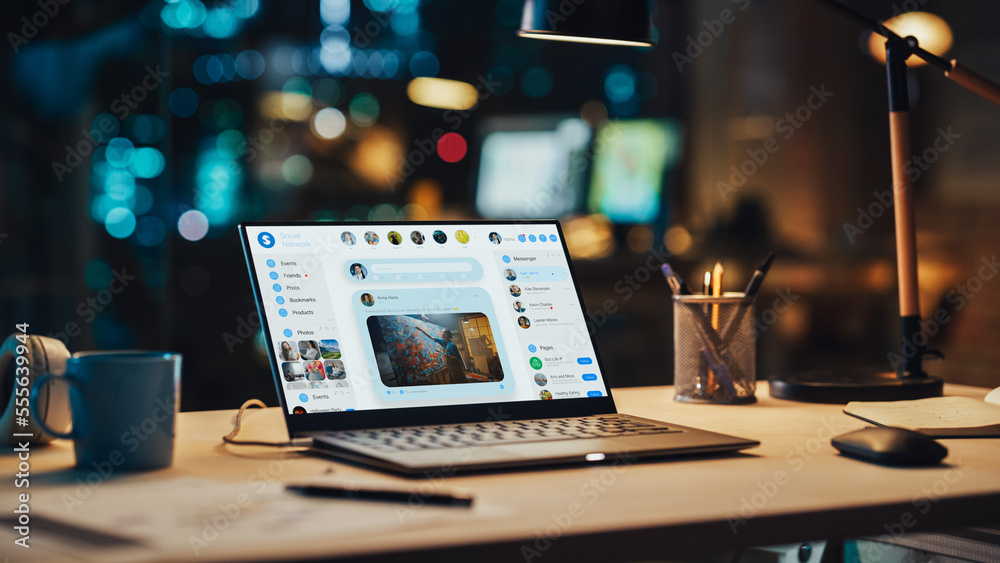 Laptop Standing on a Desk with a Social Media Platform Displayed on Screen. Table with Computer, Cof