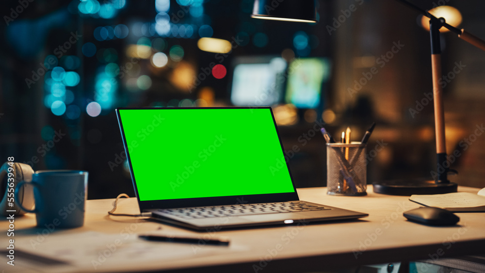 Laptop Standing on a Desk with a Green Screen Chromakey Mock Up Display. Table with Computer, Coffee