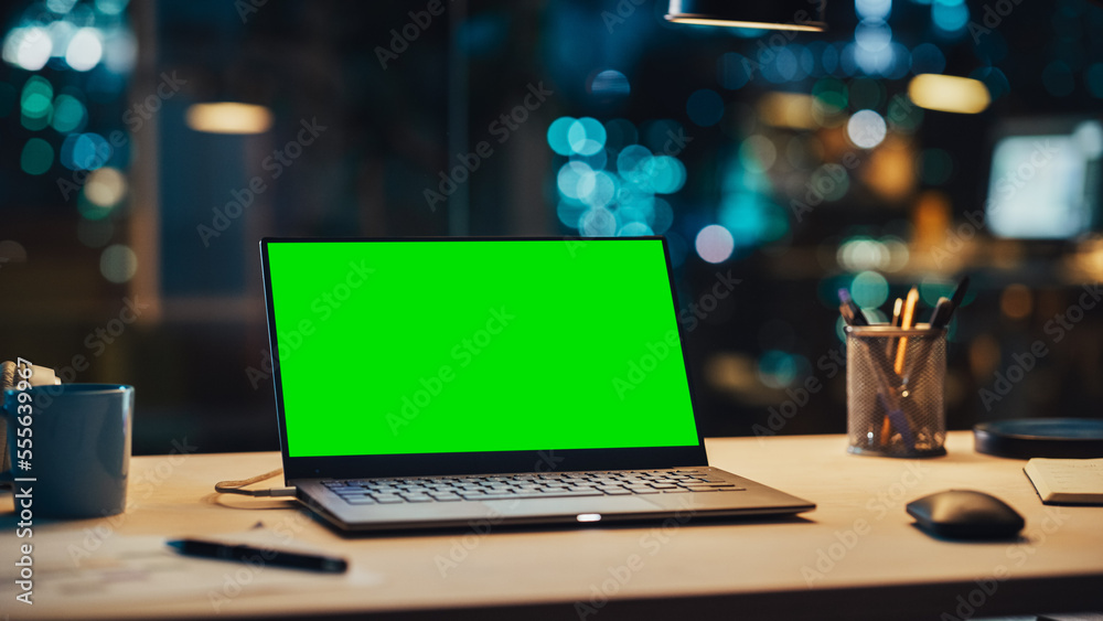 Laptop Standing on a Desk with a Green Screen Chromakey Mock Up Display. Table with Computer, Coffee