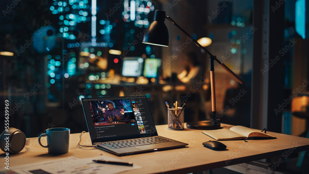 Laptop Standing on a Desk with a Video Streaming Platform Displayed on Screen. Table with Computer, 