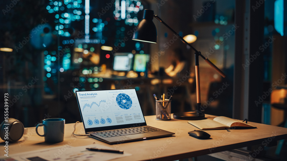 Laptop Standing on a Desk with Sales Statistics and Data Chart Displayed on Screen. Table with Compu