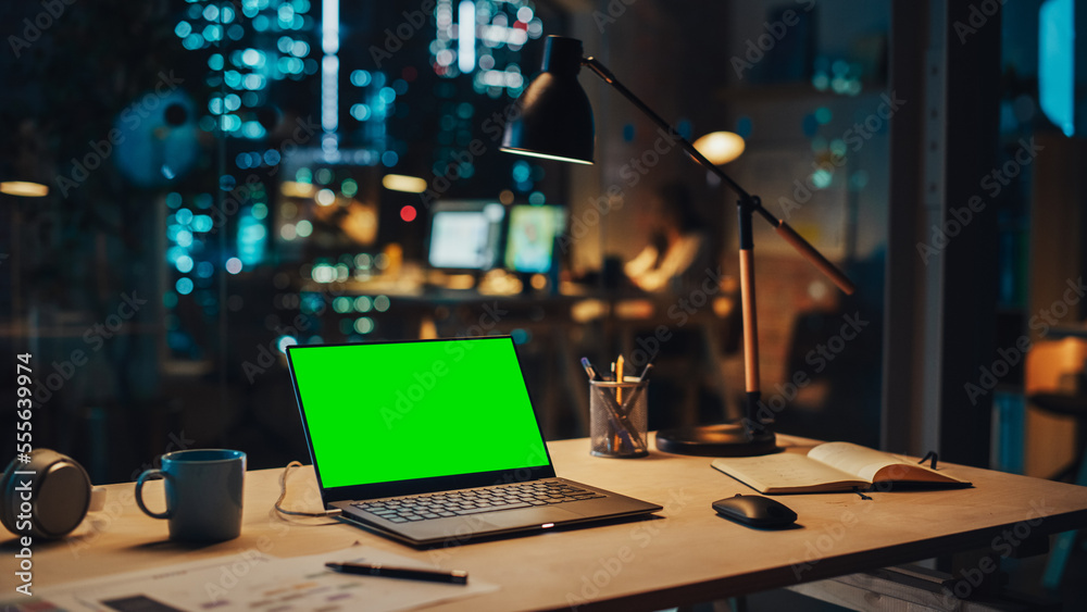 Laptop Computer with a Green Screen Chromakey Mock Up Display Standing on a Desk in the Office at Ni