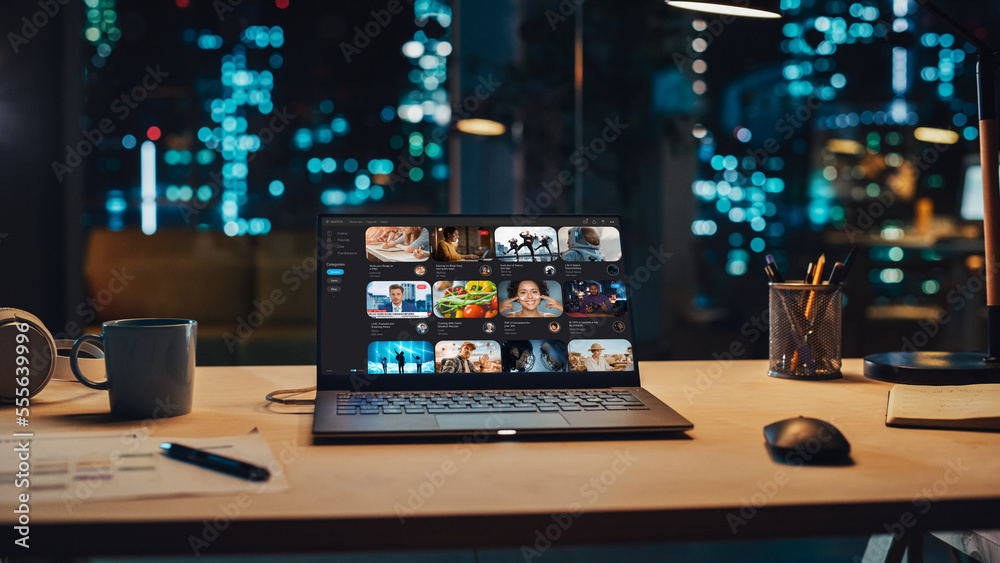 Laptop Standing on a Desk with a Video Streaming Platform Displayed on Screen. Table with Computer, 