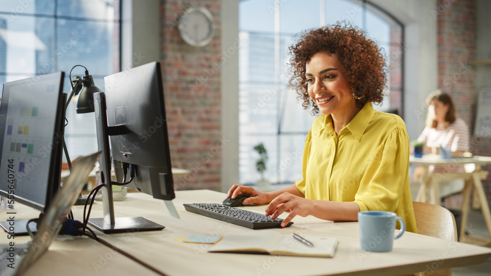 Portrait of Biracial Creative Young Woman Working on a Computer in Bright Busy Office During Day. Fe