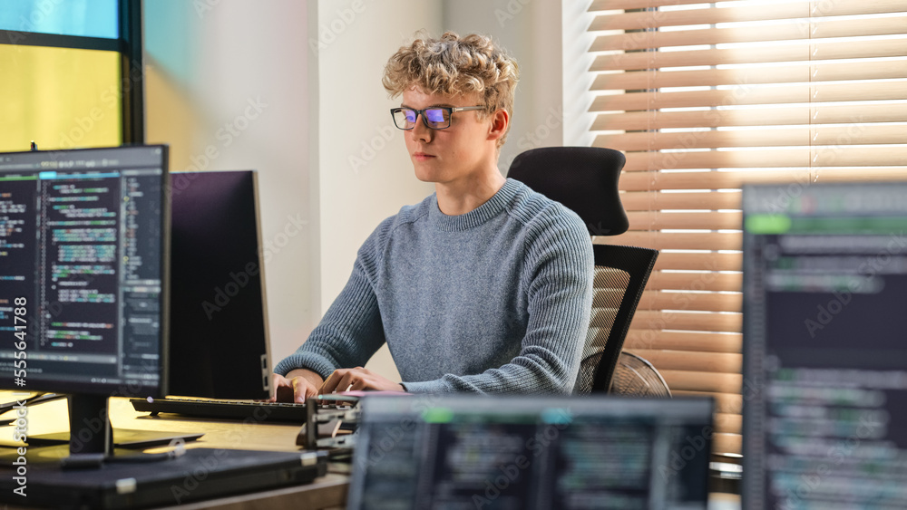 Male Software Engineer Coding On Desktop Computer in Creative Office Space. Young Caucasian Man Appl