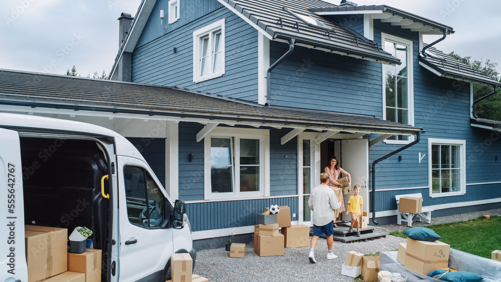 Husband, Wife and a Young Son Moving to Their New Home in Residential Area. Handsome Man Unloading a