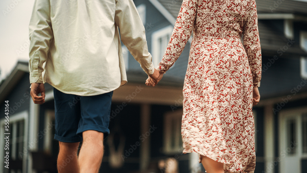 Young Beautiful Couple Walking Outdoors Towards the Country House, Holding Hands. Young Modern Famil