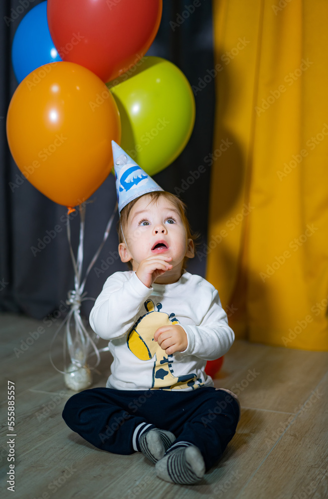 一岁生日男婴派对。带着五颜六色气球微笑的男婴。生日庆祝