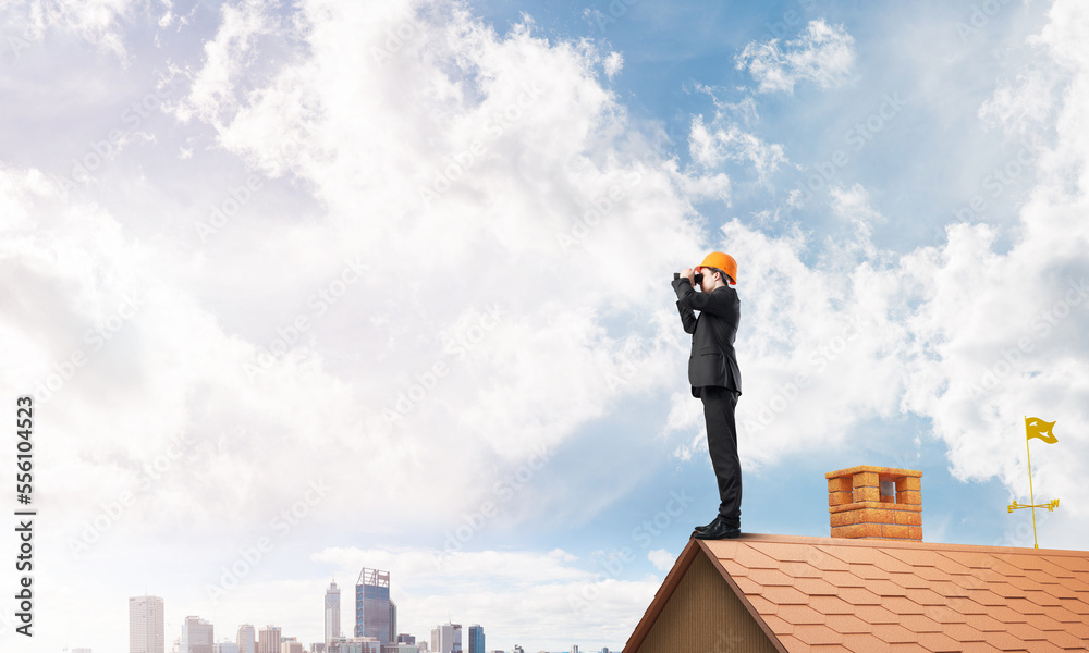 Engineer man standing on roof and looking in binoculars. Mixed media