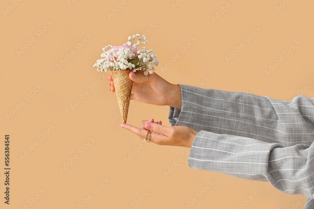 Female hands with beautiful manicure, stylish jewelry and bouquet of flowers on color background