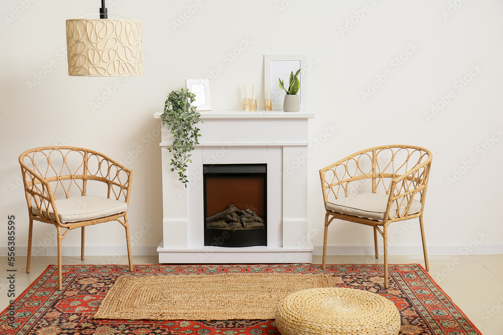 Interior of room with chairs and fireplace near white wall