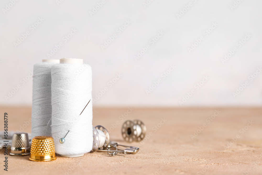 White thread spools and thimbles on color table