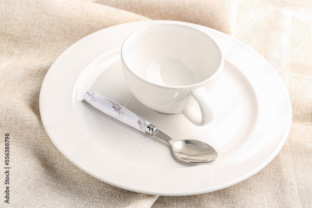 White plate with spoon and cup on napkin