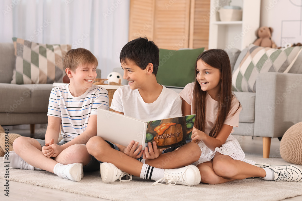 Little friends reading story on floor at home